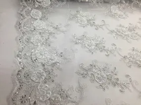 White  3d flowers embroider with sequins on a mesh lace fabric. Sold by the yard.